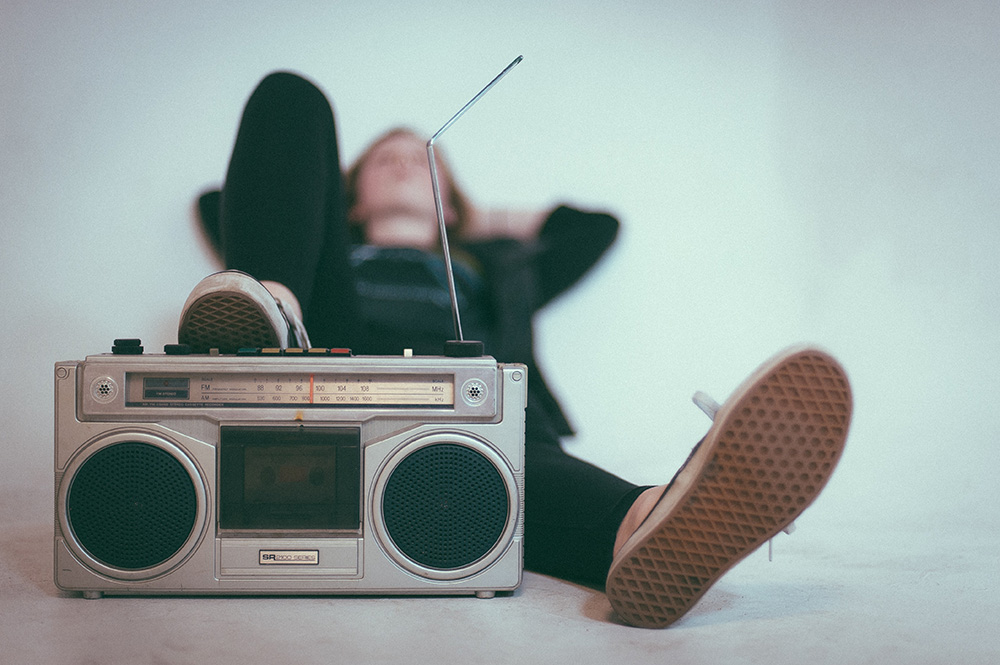 A person relaxing with one foot propped up on a radio